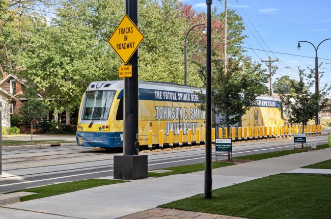 Yellow commuter train on Plaza Midwood street